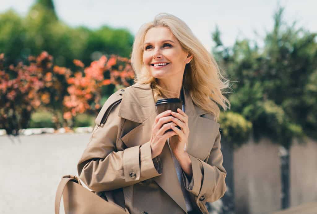Middle aged woman outside with coffee